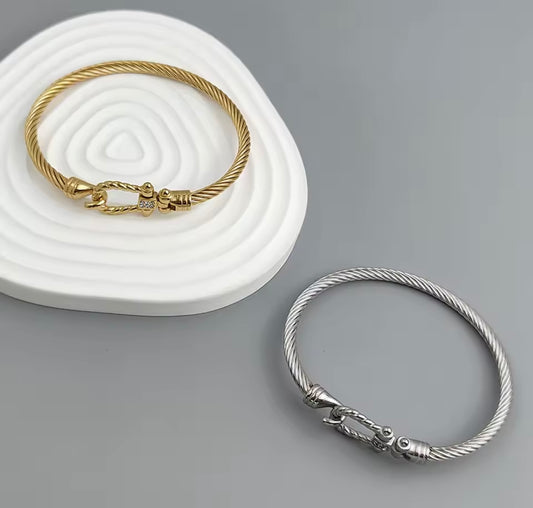 Gold and silver bracelets on a gray background